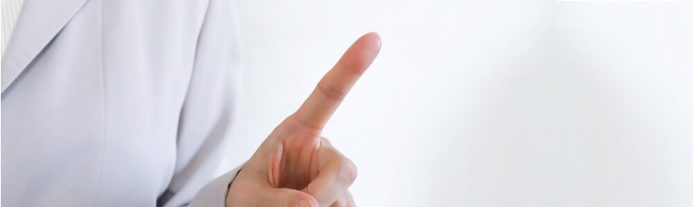 人差し指をあげている介護士